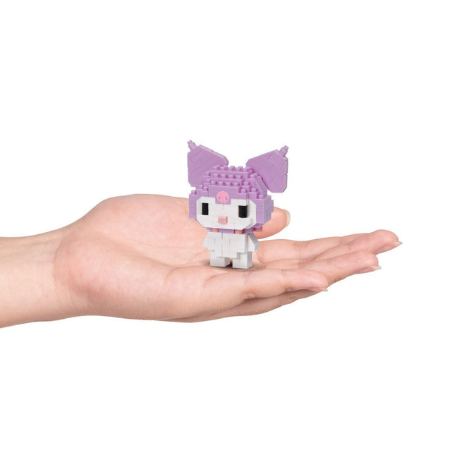A hand holding a small, purple and white toy resembling a character from a children's television show or movie.