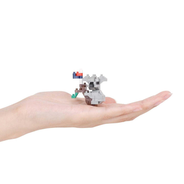A hand holding a small, colorful, pixelated toy or figurine.