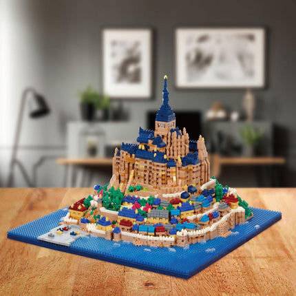 A detailed model of a castle-like structure made of colorful building blocks, resembling a Lego creation, displayed on a wooden surface.