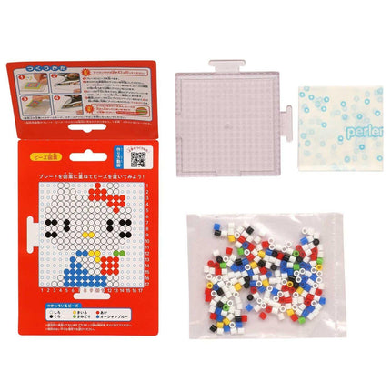 a Hello Kitty puzzle box, a clear plastic bag filled with colorful beads, and a small white square with a blue design.