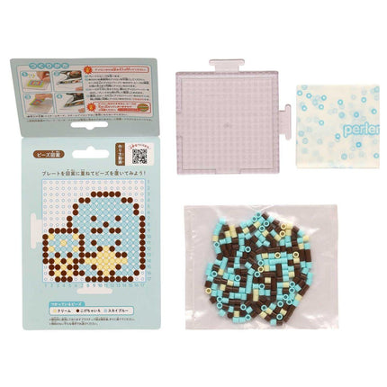 various items related to a craft or art project, including a package with instructions, a clear plastic container, and a bag filled with colorful beads.