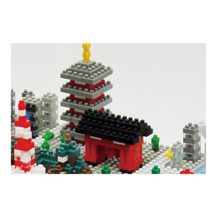 A colorful and intricate model of a cityscape made up of various building blocks and Lego bricks, including a tall tower and a red and black structure.