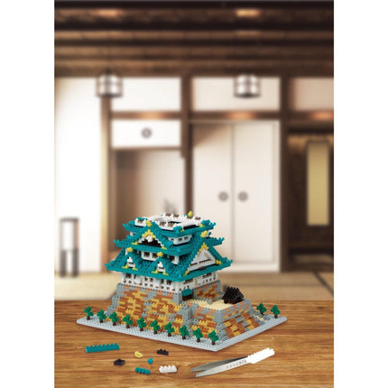 A colorful, intricate model of a castle-like structure made of small, interlocking building blocks, displayed on a wooden surface.
