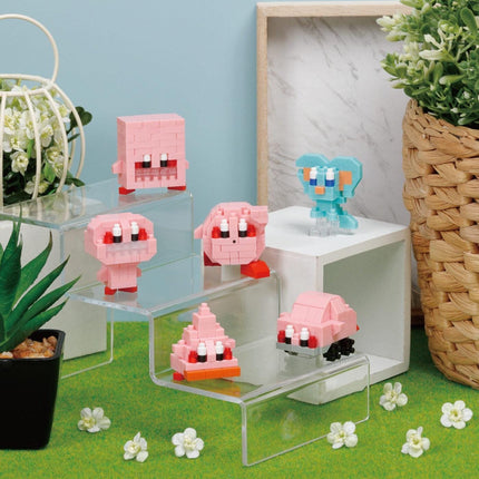 a collection of pink and blue Lego figures, including a pig, a heart, and a car, arranged on a shelf or display. The scene is set against a backdrop of potted plants and a woven basket, creating a whimsical and playful atmosphere.