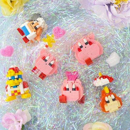 A collection of colorful, pixelated character figurines arranged on a glittery surface, surrounded by pink and white flowers.