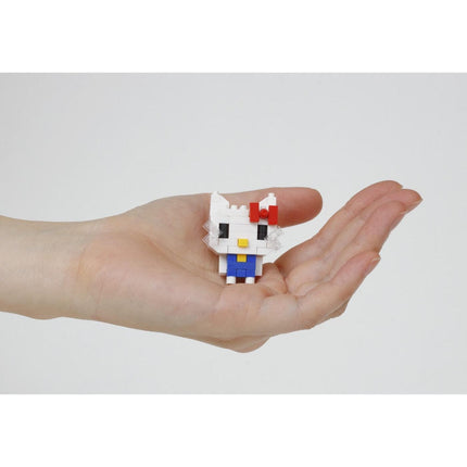 A hand holding a small, white Hello Kitty-style figure with a red bow on its head.