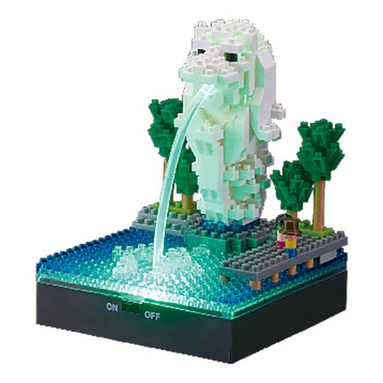 A miniature model of the Singapore Flyer, a famous landmark, made of small, colorful building blocks. The Flyer is situated on a small body of water, with a fountain-like structure sprouting from it. The scene is illuminated by a green light, creating a vibrant and lively atmosphere.