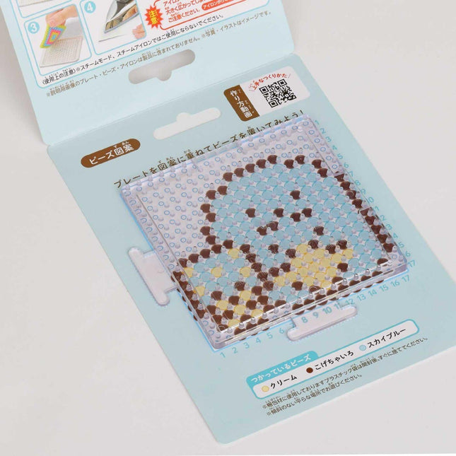 a product packaging for a craft item, specifically a bead board or bead mat. The packaging has a light blue background with a pattern of small circles and dots, and there is some text and a QR code visible on the packaging.