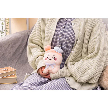 Sitting plush toy in white with pink accents and a small gray ear detail