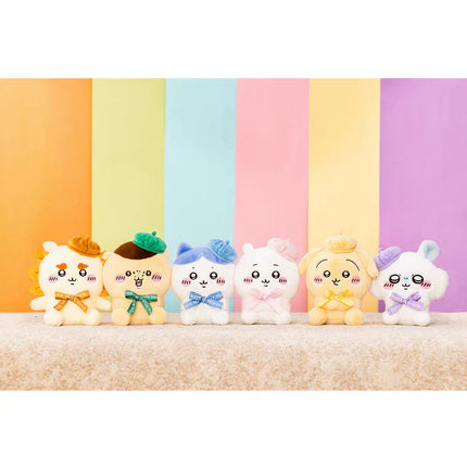 Set of sitting plush toys with orange, green, blue, pink, and purple outfits