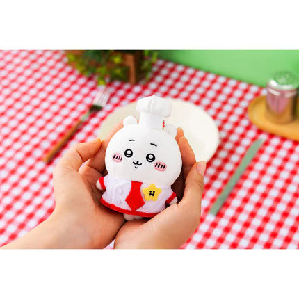 Plush restaurant chef mascot held in hand, white outfit with red apron and hat