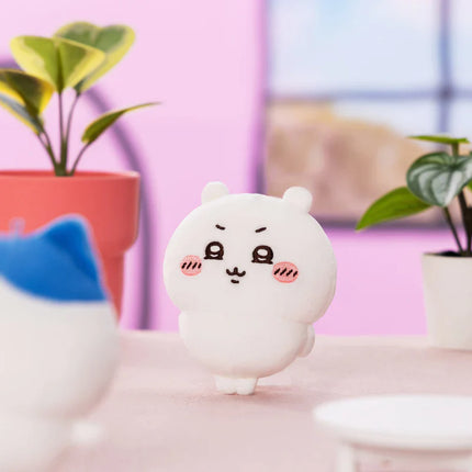 White plush mascot with rounded face, black eyes, and pink blush cheeks