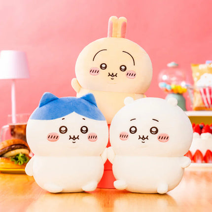 Chubby hand-sized plush toys, three characters in cream and blue with smiling faces