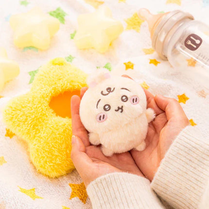 Small yellow star-shaped plush mascot with rabbit face, held in hands.