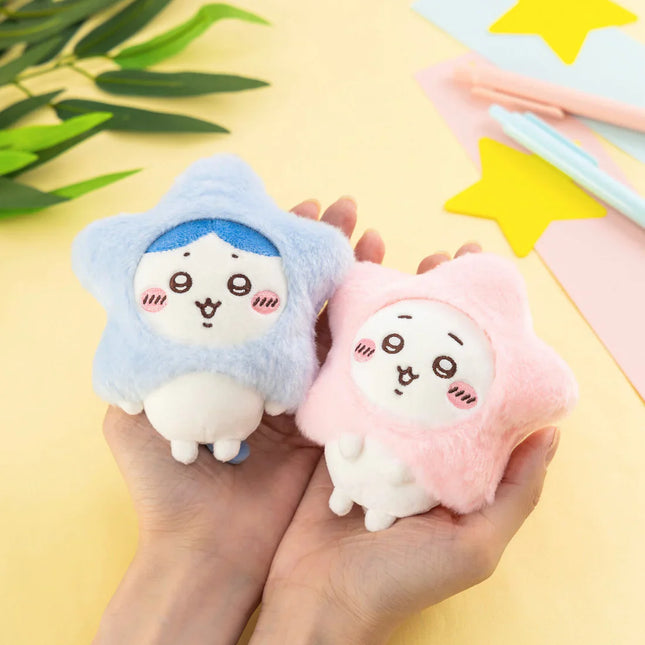 Two star-shaped plush mascots with blue and pink hood-like covers held in hands.