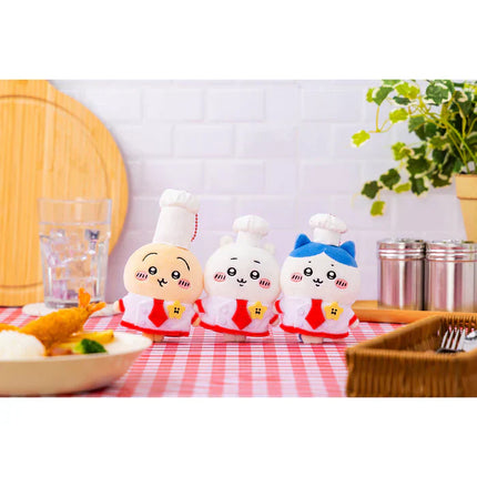 Three plush restaurant chef mascots in white outfits with red accents, standing together