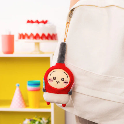 Red-and-white plush mascot keychain with tall gray hat, attached to a white hoodie