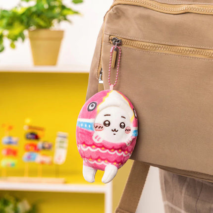 Pink plush hanging mascot keychain on a tan zipper bag