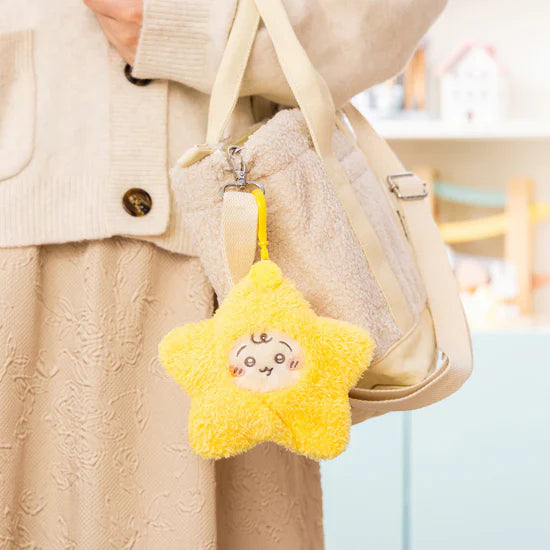 Yellow star plush charm with rabbit face attached to a tote bag strap.